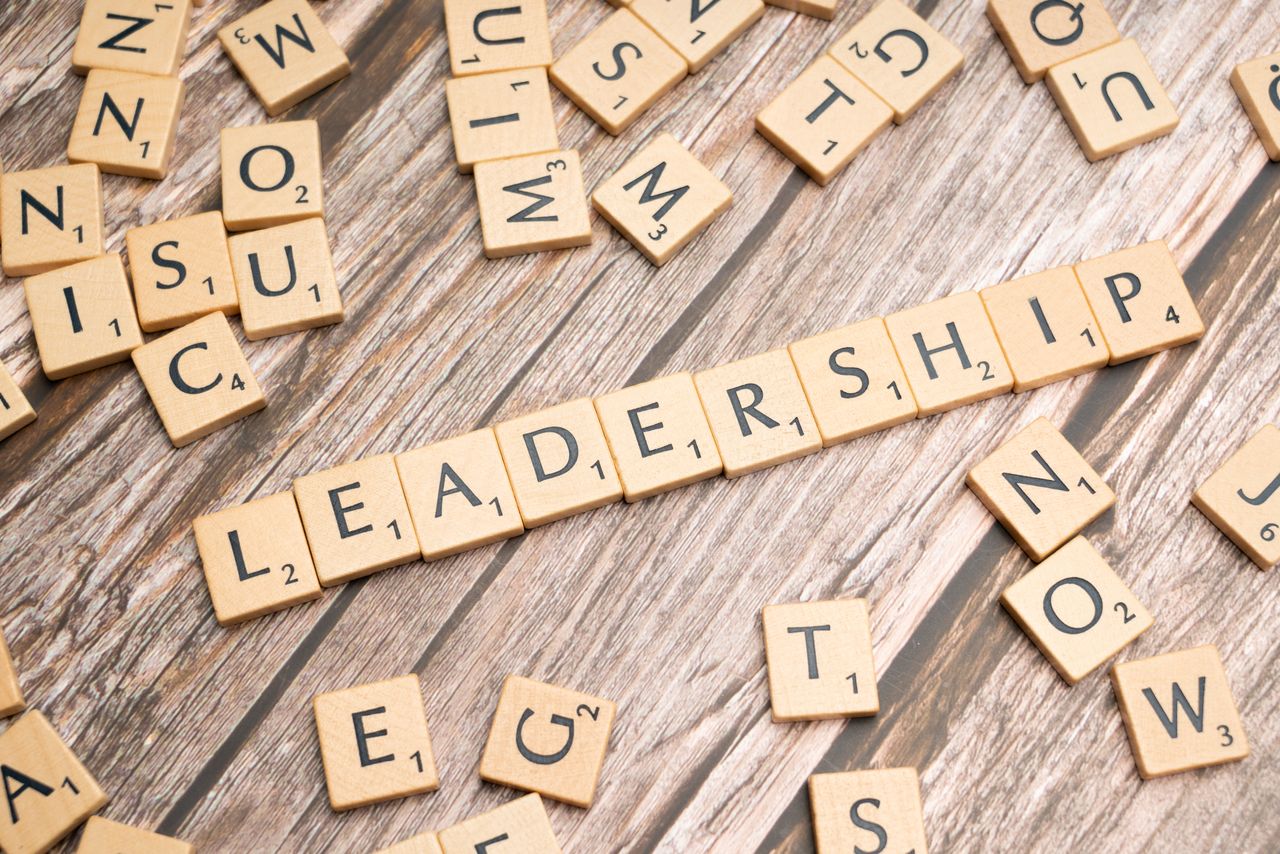 services-03 Wooden letter tiles spelling LEADERSHIP on a wooden surface, symbolizing leadership qualities and skills.
